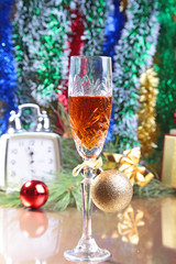 Fototapeta na wymiar Glass of sparkling shampagne wine clock and gift box on christmas background