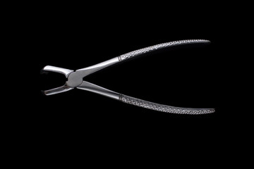 Obraz premium Dental pincers to remove the chewing teeth on black background