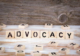 Advocacy from wooden letters on wooden background.
