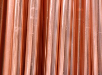 A row of copper pipes. A clear photo of a finished product, derived from a natural chemical element, copper ore. For the replacement or installation of a water pipe during the renovation of a house.