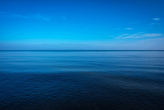 Fototapeta Tranquil dark and deep ocean with blue sky