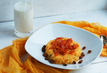 porridge of millet cereal with a pumpkin raisins and dried apricots on a white background 