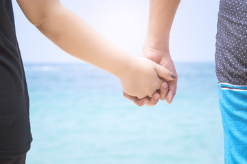 Concept love, Young couple in love on the beach holding hands looking in the sea. Love together.