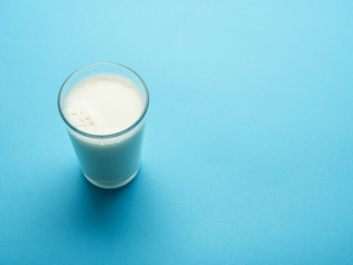 Glass of milk on the blue background.