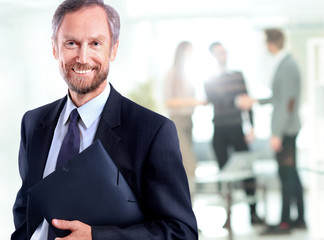 Happy mature business man looking at camera with satisfaction at office