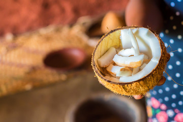 Half of coconut in woman's hands
