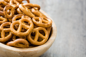 Salted pretzel in bowl on wooden background.Copyspace