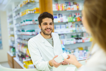 Experienced pharmacist counseling female customer in modern phar