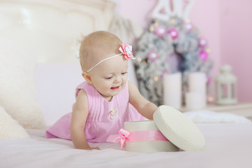 beautiful little girl opening a Christmas gift, the background  tree