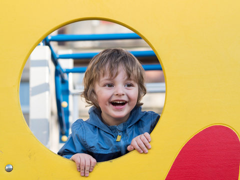 Funny cute happy baby playing on the playground. The emotion of happiness, fun, joy. Smile of a ?hild.