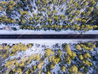 Aerial photo of empty black road, trees and snow - horizontal