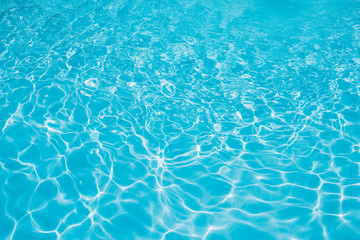 Blue and bright water in swimming pool with sun reflection