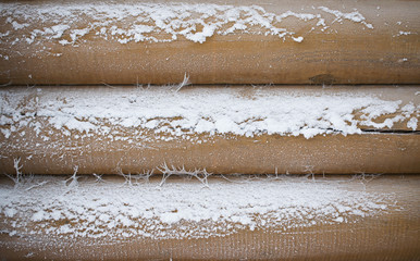 Background of natural wooden logs in frost