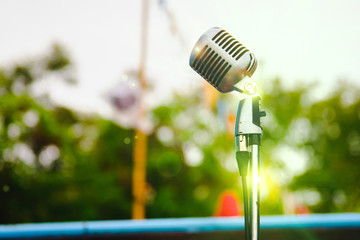 Retro microphone on vintage outdoor background.