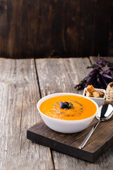 Pumpkin carrot soup on wooden background