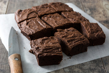 Chocolate brownie portions on wooden background
