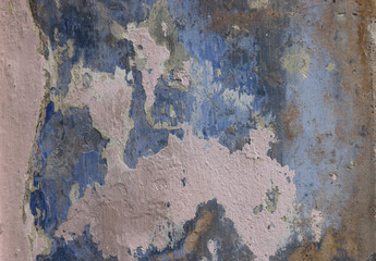 Multicolored and multilayer peeling paint. Old concrete background. Broken wall. Abstract textures.