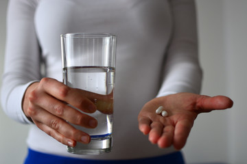 Woman with pill and glass of water