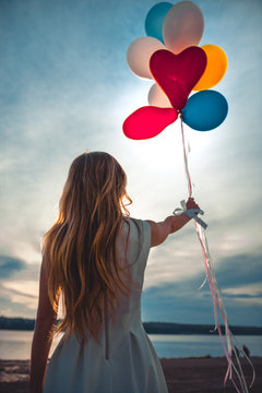girl holding balls on the background of sunset