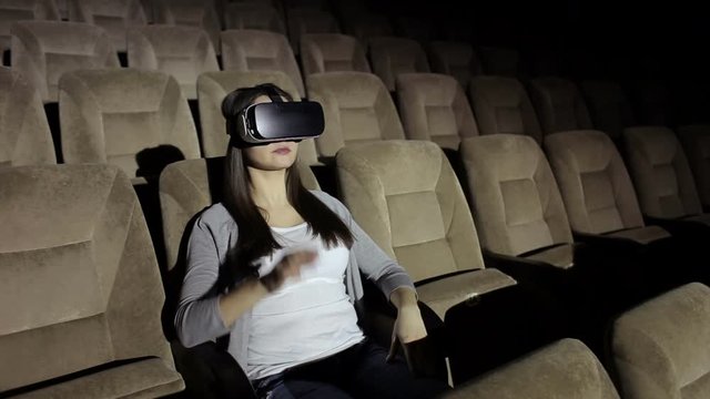 Portrait of caucasian woman with virtual reality goggle in empty theatre. VR-headset glasses of virtual reality.