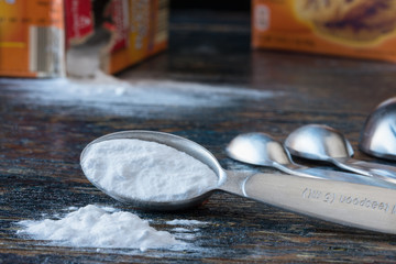 Obraz na płótnie Canvas Baking soda spilling from a measuring spoon