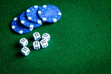 poker chips and dice on green background top view