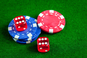 poker chips and dice on green background top view
