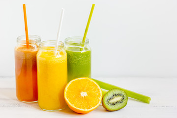 Fresh detox juices in glass bottles on white background