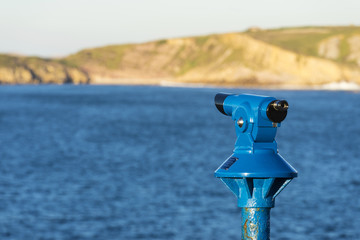 Blue panoramic telescope with the sea as background
