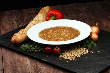 
Lentil soup with pita bread in a bowl on a wooden background