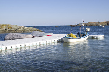 Obraz premium Plastic pontoon with two covered boats and fishing boat
