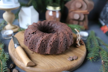 Chocolate cake with caramel and spices on rustic background for winter recreation. Christmas and New Year decorations