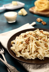 boiled Italian tagliatelle noodles on wood background