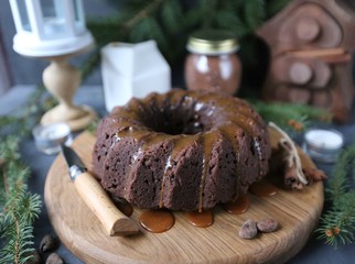 Chocolate cake with caramel and spices on rustic background for winter recreation.  Christmas and New Year decorations