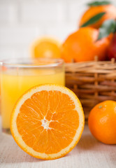 Fresh orange juice in a glass on a background of fruit baskets