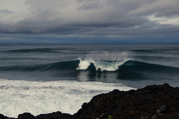 Surfer surfing a perfect wave on a stormy day in azores islands, Portuga