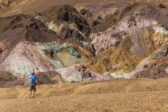 Men taking a picture of colored rocks "Artist Pallete" in Death Valley National Park, California, USA.