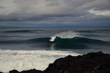 Surfer surfing a perfect wave on a stormy day in azores islands, Portuga