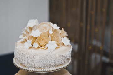 Wedding cake decorated with beige flowers from the cream 6720.