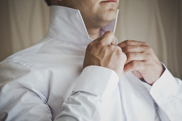 Young man buttoning a button the gates shirt 6807.