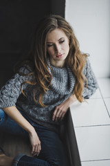 The girl in home clothes sitting at the window 6992.