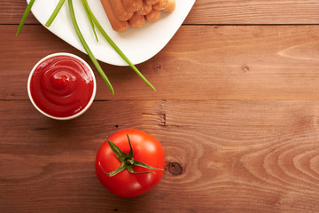ketchup and tomato on a wooden table top