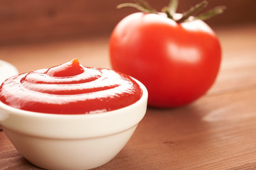 ketchup and tomato on a wooden table