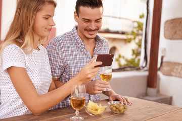Sweet couple looking at cellphone satisfied