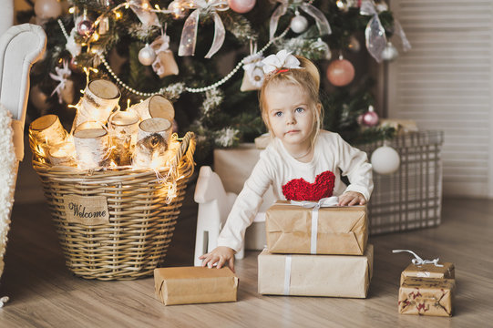 Portrait of a child sitting on the floor near the Christmas tree