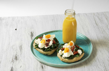 Sandwich with spinach, boiled egg and dried tomatoes and orange juice