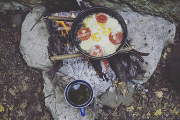 Cooking breakfast on a campfire at a summer camp.