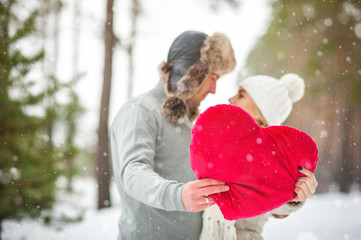 couple in the forest in winter, walk, kiss, hug and hold hands heart