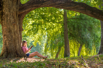 Girl reading book at park
