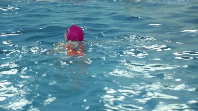 Girl learns to swim in the pool
